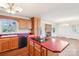 Open-concept kitchen featuring wooden cabinets, a red countertop island with a cooktop, and a view into the living room at 108 Colonial Dr, Kings Mountain, NC 28086