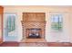 Cozy living room featuring a brick fireplace, wood flooring, and natural light through the windows at 108 Colonial Dr, Kings Mountain, NC 28086
