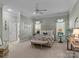 Bright main bedroom with a tufted headboard, a decorative bench, and lots of natural light from the large windows at 1158 South S St, Cornelius, NC 28031