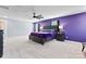 Spacious bedroom with large bed, plush carpet, and a striking purple accent wall at 1195 Cavalier Ln, Rock Hill, SC 29730