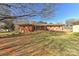 Spacious backyard showing the brick home, an enclosed patio, and a large lawn at 1356 Ford Dr, Lowell, NC 28098