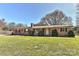 Charming brick home with manicured lawn, mature trees, and updated black shutters and trim at 1356 Ford Dr, Lowell, NC 28098