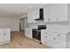 Bright kitchen features white cabinets, stainless steel appliances, patterned backsplash, and modern hardware at 1356 Ford Dr, Lowell, NC 28098