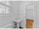Clean bathroom featuring a sink, toilet, and window with shuttered blinds at 1626 Beverly Dr, Charlotte, NC 28207