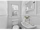 Charming bathroom featuring a pedestal sink, window with shutters, and classic white fixtures at 1626 Beverly Dr, Charlotte, NC 28207