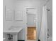 Clean bathroom with a pedestal sink and tub/shower combo with a peek into bedroom at 1626 Beverly Dr, Charlotte, NC 28207