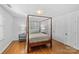 Light filled bedroom features hardwood floors, four poster bed, two windows and neutral color palette at 1626 Beverly Dr, Charlotte, NC 28207