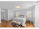 Bright bedroom featuring hardwood floors, white walls, and a large bed at 1626 Beverly Dr, Charlotte, NC 28207