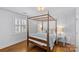 Bright bedroom with a four-poster bed, hardwood floors, and large windows at 1626 Beverly Dr, Charlotte, NC 28207