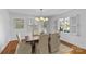 Dining room with hardwood floors, bright windows, and a modern light fixture at 1626 Beverly Dr, Charlotte, NC 28207