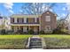 Charming two-story brick home with a well-manicured lawn and a stone pathway leading to the front door at 1626 Beverly Dr, Charlotte, NC 28207