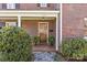 Classic brick home with a covered entrance featuring a wooden door and manicured greenery at 1626 Beverly Dr, Charlotte, NC 28207