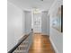 Long hallway with hardwood floors, white walls, and natural light from window at 1626 Beverly Dr, Charlotte, NC 28207