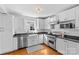 Well-lit kitchen featuring stainless appliances, white cabinets, and stone countertops at 1626 Beverly Dr, Charlotte, NC 28207