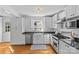Eat-in kitchen with white cabinets, stainless steel appliances, and stone countertops at 1626 Beverly Dr, Charlotte, NC 28207