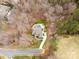 A stunning aerial view of a secluded home with a pool, surrounded by dense trees and a winding driveway at 2007 Fernhurst Ter, Matthews, NC 28104