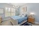 Cozy bedroom with blue accents, a decorative chandelier, and natural light streaming through the window at 2007 Fernhurst Ter, Matthews, NC 28104