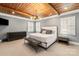 Comfortable main bedroom with wood ceiling beams, a king bed, and natural light at 2007 Fernhurst Ter, Matthews, NC 28104