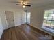 Well-lit bedroom with hardwood floors, ceiling fan, and two windows at 2190 Pacer Rd, Lancaster, SC 29720