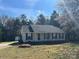 Charming one-story home featuring a covered front porch, gray siding, and a well-maintained lawn with mature trees at 2190 Pacer Rd, Lancaster, SC 29720