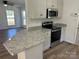Kitchen boasts granite countertops, stainless steel oven and microwave, and white cabinets with black hardware at 2190 Pacer Rd, Lancaster, SC 29720