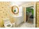 Bathroom with floral wallpaper, white vanity, octagonal mirror, and accessible toilet at 2455 Wellridge Rd, Chester, SC 29706