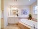 Bright bathroom with a soaking tub, vanity with sink, and neutral tile flooring at 2538 Cherry Bark Oak Ct, Gastonia, NC 28056