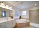 Bright bathroom featuring a soaking tub, vanity, shower, and decorative wall art at 2538 Cherry Bark Oak Ct, Gastonia, NC 28056