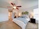Cozy primary bedroom with a ceiling fan, soft carpet, ensuite bath, and an artistic print at 2538 Cherry Bark Oak Ct, Gastonia, NC 28056