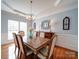 Charming dining room featuring a classic chandelier, hardwood floors, and elegant wainscoting detail at 2538 Cherry Bark Oak Ct, Gastonia, NC 28056