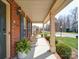 Welcoming covered porch with comfortable seating, accented by lush plants and charming curb appeal at 2538 Cherry Bark Oak Ct, Gastonia, NC 28056