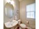 Charming half bathroom with a pedestal sink, round mirror, and natural light from the window at 2538 Cherry Bark Oak Ct, Gastonia, NC 28056