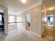 Upstairs hallway with neutral carpet, decorative chandelier and views into the bedrooms at 2538 Cherry Bark Oak Ct, Gastonia, NC 28056