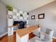 Bright home office features built-in shelving, a wooden desk, and comfortable seating area at 2538 Cherry Bark Oak Ct, Gastonia, NC 28056