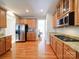 Spacious kitchen with wooden cabinets, granite countertops, stainless steel appliances, and wooden floors at 2538 Cherry Bark Oak Ct, Gastonia, NC 28056