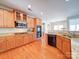 Bright kitchen with granite counters, stainless appliances, and wood cabinets, seamlessly connecting to breakfast area at 2538 Cherry Bark Oak Ct, Gastonia, NC 28056