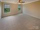 The bedroom features neutral carpet, two windows and a ceiling fan at 2927 Clemson Ave, Charlotte, NC 28205