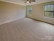 The bedroom features neutral carpet, two windows and a ceiling fan at 2927 Clemson Ave, Charlotte, NC 28205