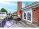 Back porch featuring double french doors, brick chimney, patio set and wooden flooring at 30 Hillsboro Rd, Taylorsville, NC 28681