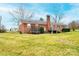 Expansive backyard featuring a trampoline, brick home, deck and mature trees at 30 Hillsboro Rd, Taylorsville, NC 28681