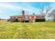 Expansive backyard featuring a trampoline, brick home, deck and mature trees at 30 Hillsboro Rd, Taylorsville, NC 28681