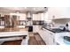 A well-equipped kitchen with white cabinets, stainless appliances, black countertops, and an island with breakfast bar seating at 30 Hillsboro Rd, Taylorsville, NC 28681