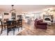 Open-concept living space with modern floors and a cozy brick fireplace, seamlessly connecting living, dining, and kitchen areas at 30 Hillsboro Rd, Taylorsville, NC 28681