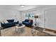 Inviting living room features hardwood floors, white walls, blue seating and natural light at 3036 Marlowe Ave, Charlotte, NC 28208