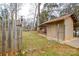 View of a backyard featuring a shed, wooden fence with basketball hoop, and sparse grass lawn at 3901 Durham Ln, Charlotte, NC 28269