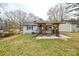 Expansive backyard with a covered deck, a well-maintained lawn, and mature trees at 3901 Durham Ln, Charlotte, NC 28269