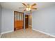 This bedroom features tile flooring, a closet with louvered doors, and a ceiling fan, creating a comfortable interior at 3901 Durham Ln, Charlotte, NC 28269