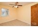 A bright bedroom includes tile flooring, a window, and a ceiling fan, creating a cozy and cheerful ambiance at 3901 Durham Ln, Charlotte, NC 28269