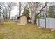 Backyard with a wooden shed, and a metal shed, all surrounded by a grassy lawn at 3901 Durham Ln, Charlotte, NC 28269