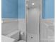 View of a white-tiled bathroom with light blue walls, shower stall, and toilet with paper at 407 Pinecroft Ln, Spencer, NC 28159